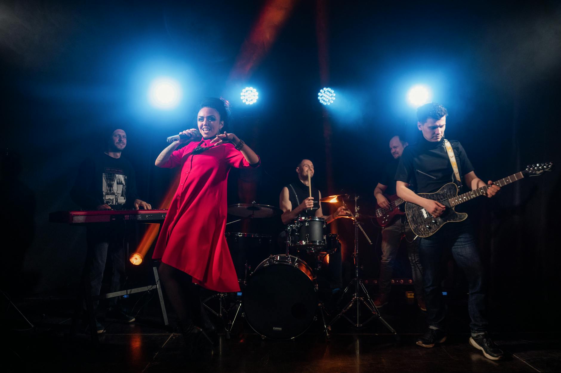 Zespół rockowy gra na scenie w kolorowych światłach reflektorów