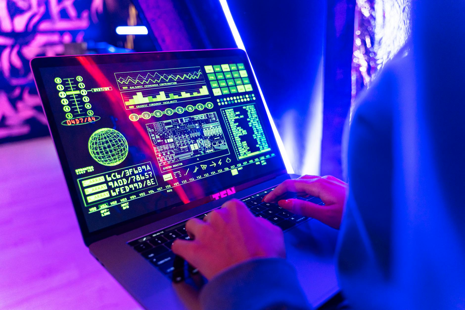 Osoba pisząca na laptopie z kolorowymi danymi i ikoną cyberbezpieczeństwa